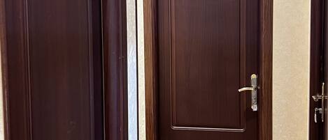 A hallway with wooden doors, one marked with the number 101, leading to a room.
