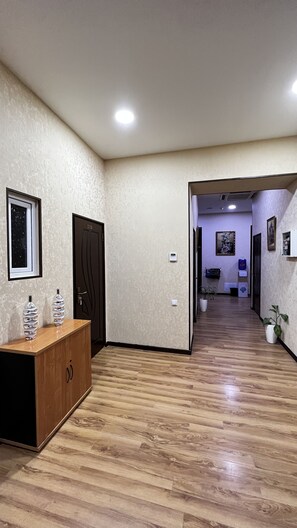 Stylish hallway with a door to a cozy room featuring a bed and a window.