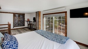Ein Schlafzimmer mit einem großen Bett, einem Schreibtisch und einem Fernseher.