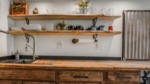 Eine Küche mit Holzböden, einer Spüle und einer rustikalen Arbeitsplatte.