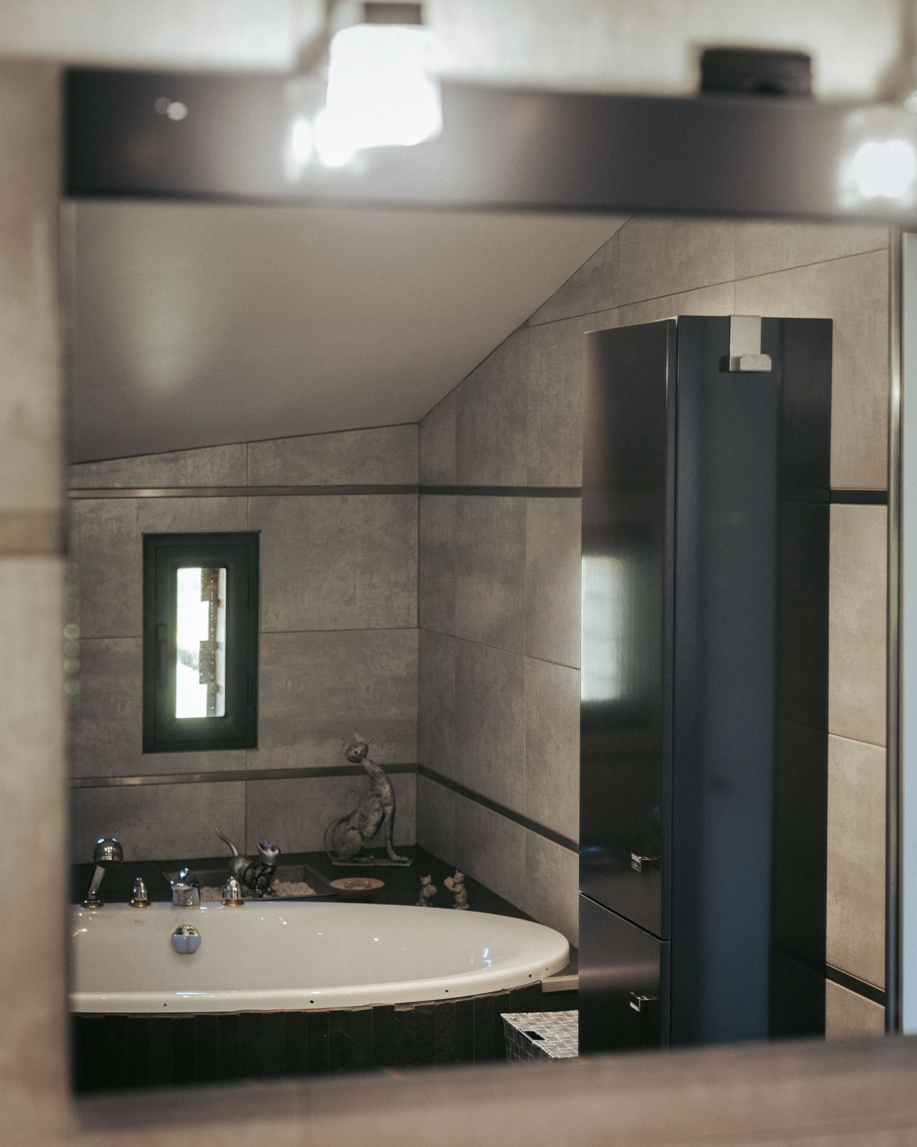 Un baño moderno con una bañera grande, un espejo y un inodoro.