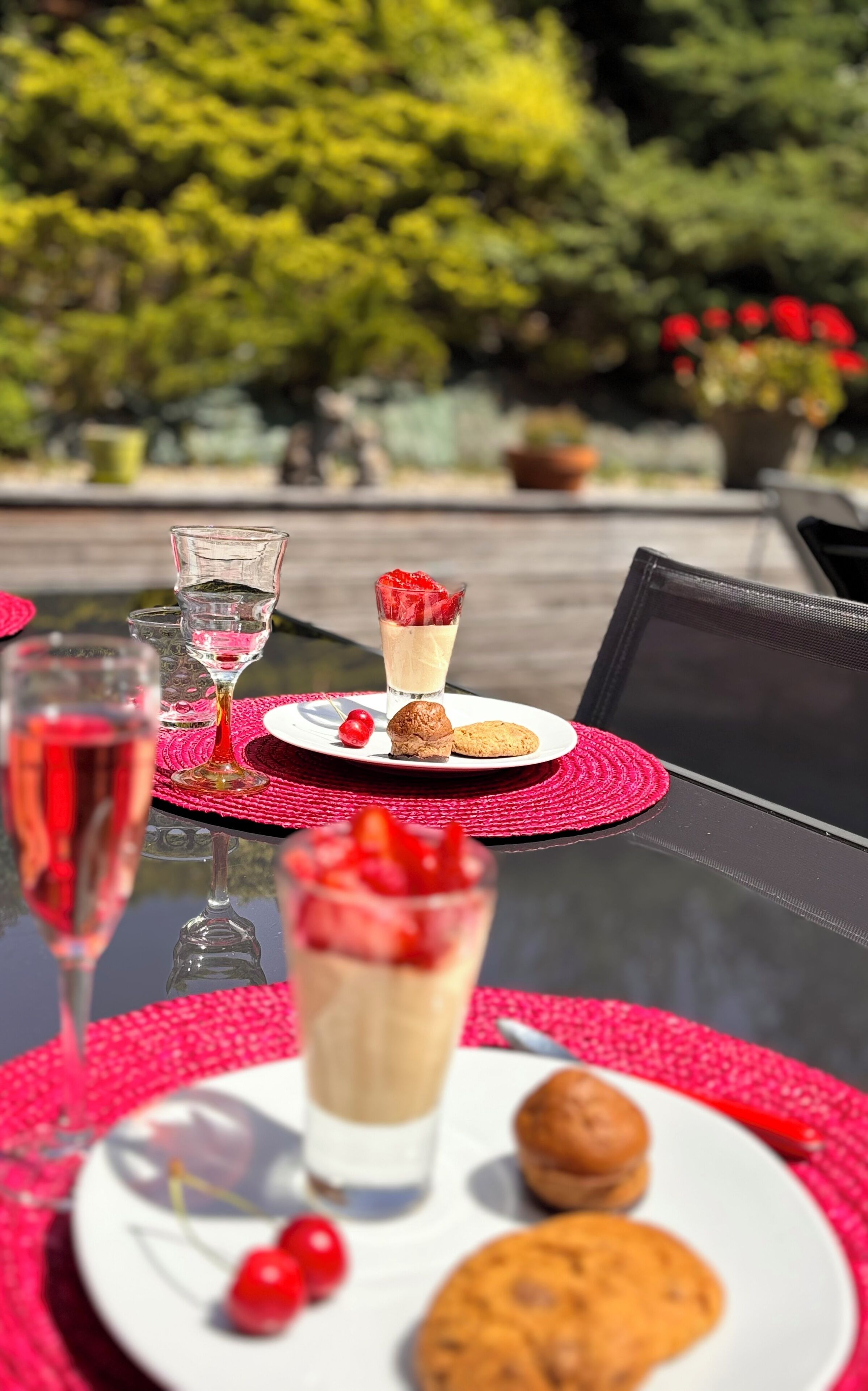 Una tavola imbandita con un dessert, un bicchiere di vino e un biscotto.