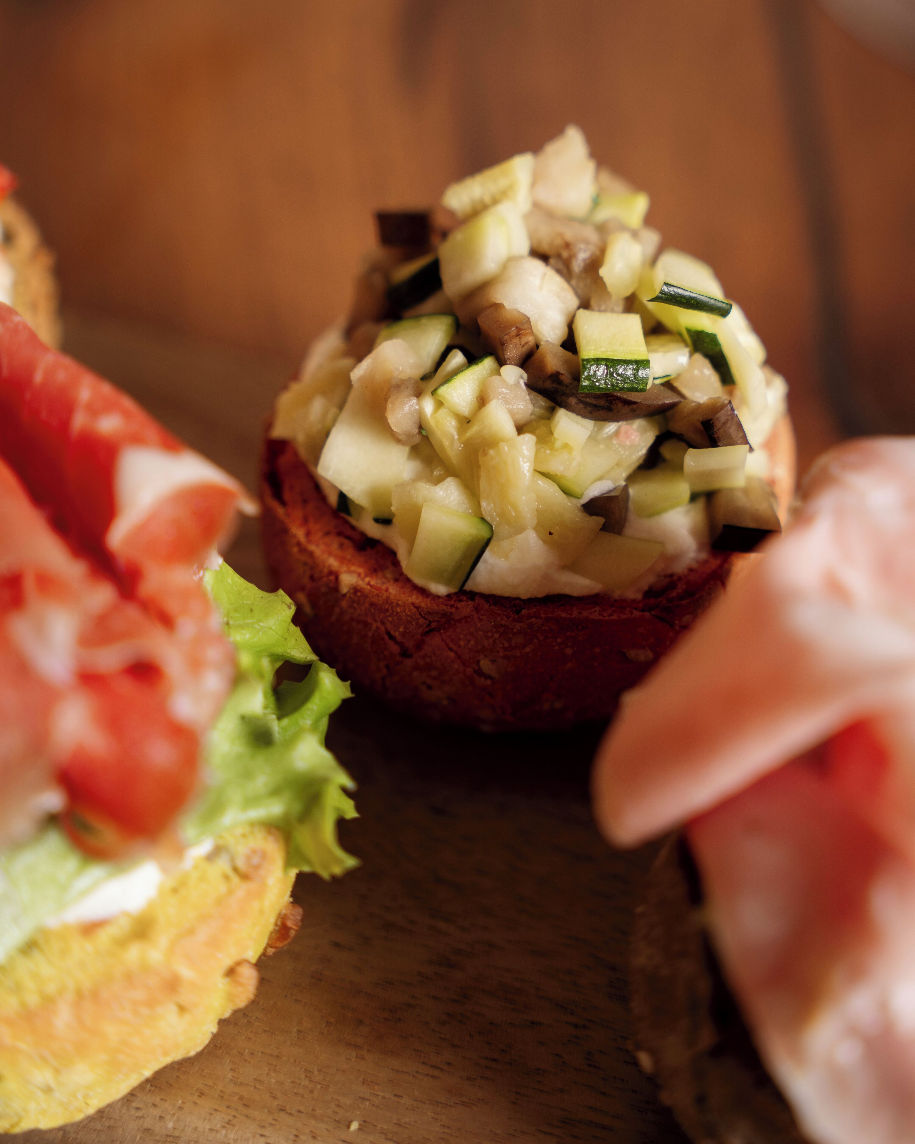 Ein Sandwich mit verschiedenen Gemüsesorten auf einer Holzunterlage.