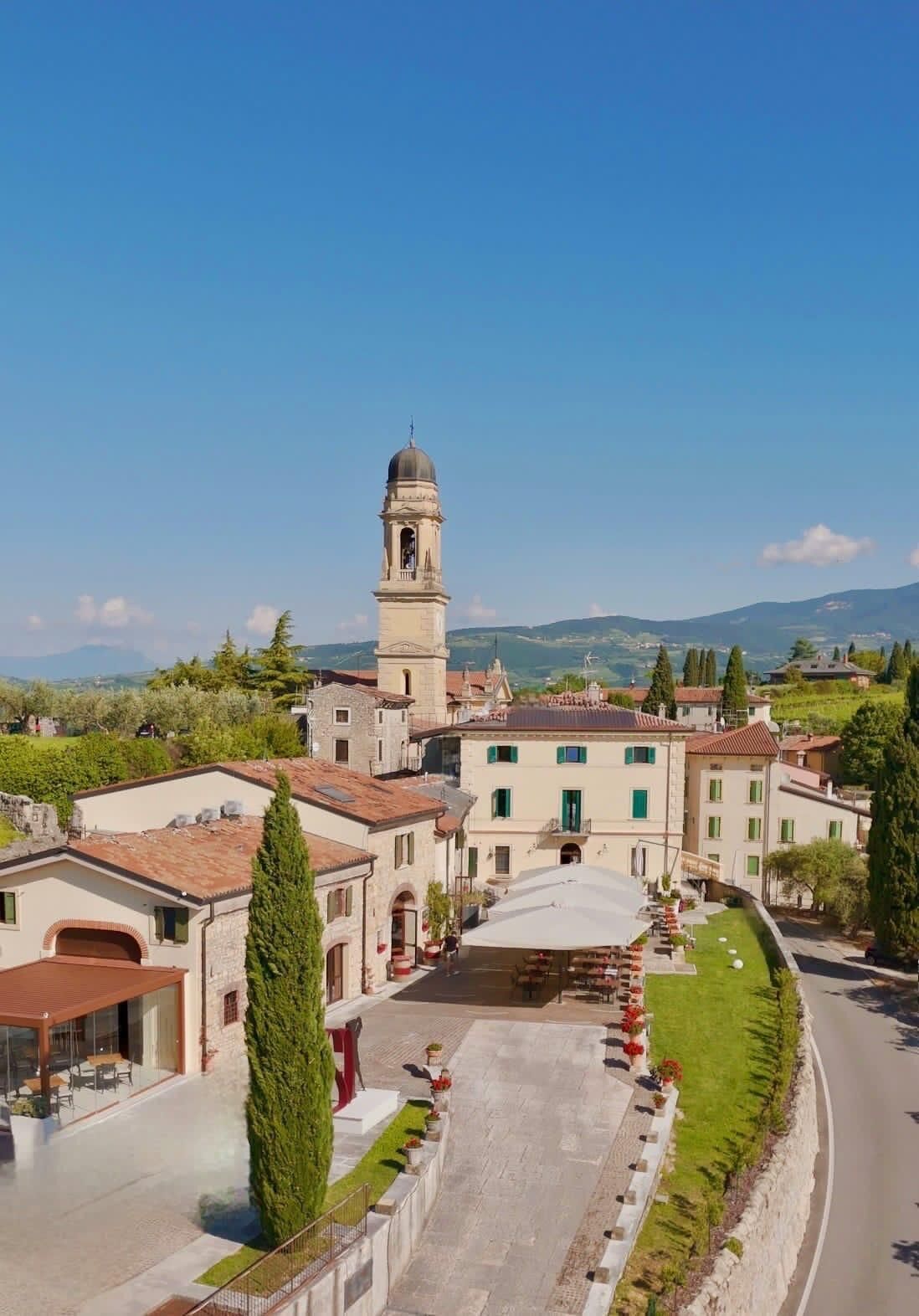 Une ville historique dotée d’un imposant clocher, de bâtiments traditionnels et d’une place pavée agrémentée de sièges en plein air.
