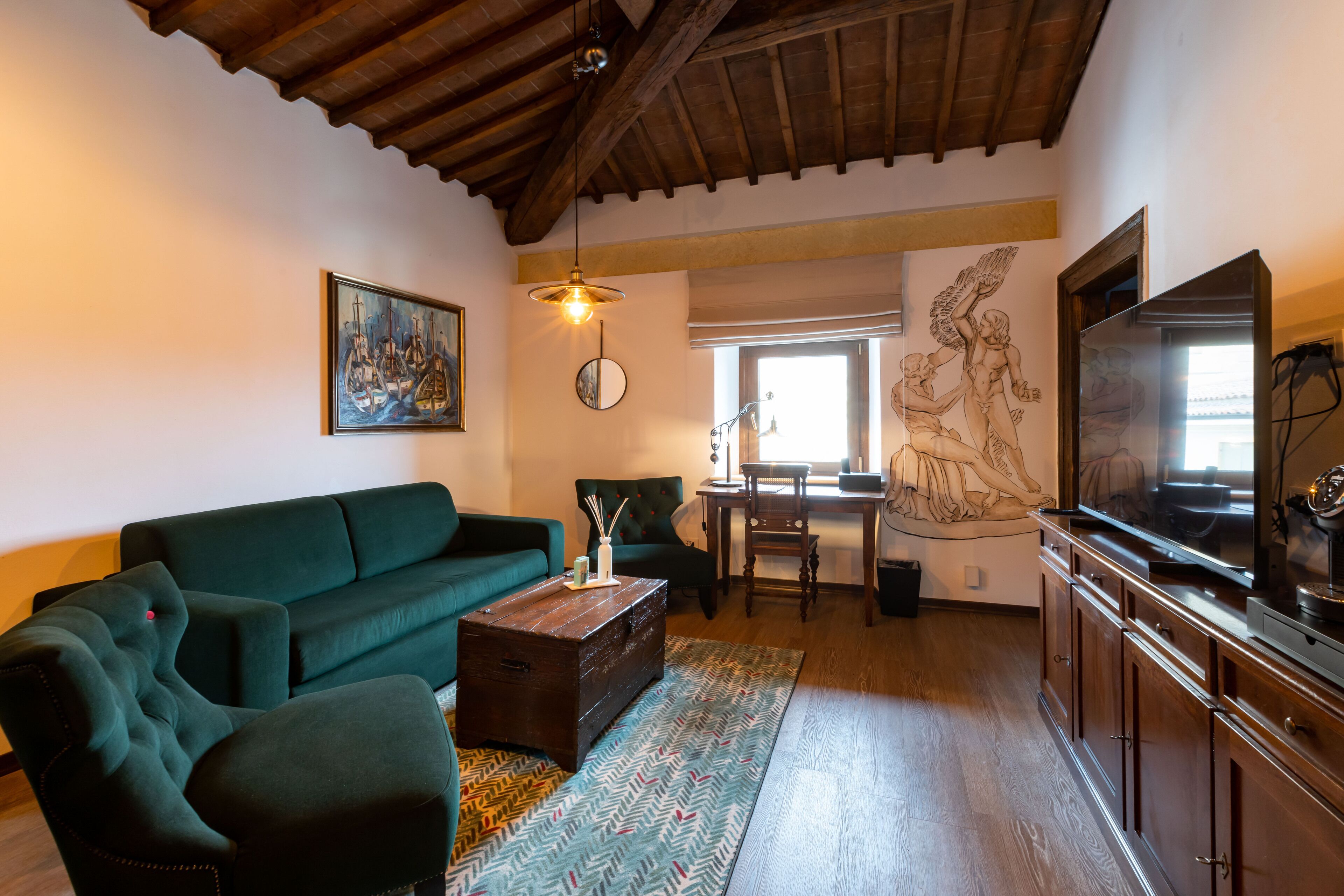A living room with a green sofa, wooden coffee table, and a TV on a wooden cabinet.