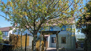 A residential property with a wooden gate, a pathway leading to a house, and a clear sky. - Pet friendly, comfortable family home with sea views near the Giant's Causeway (Bushmills)