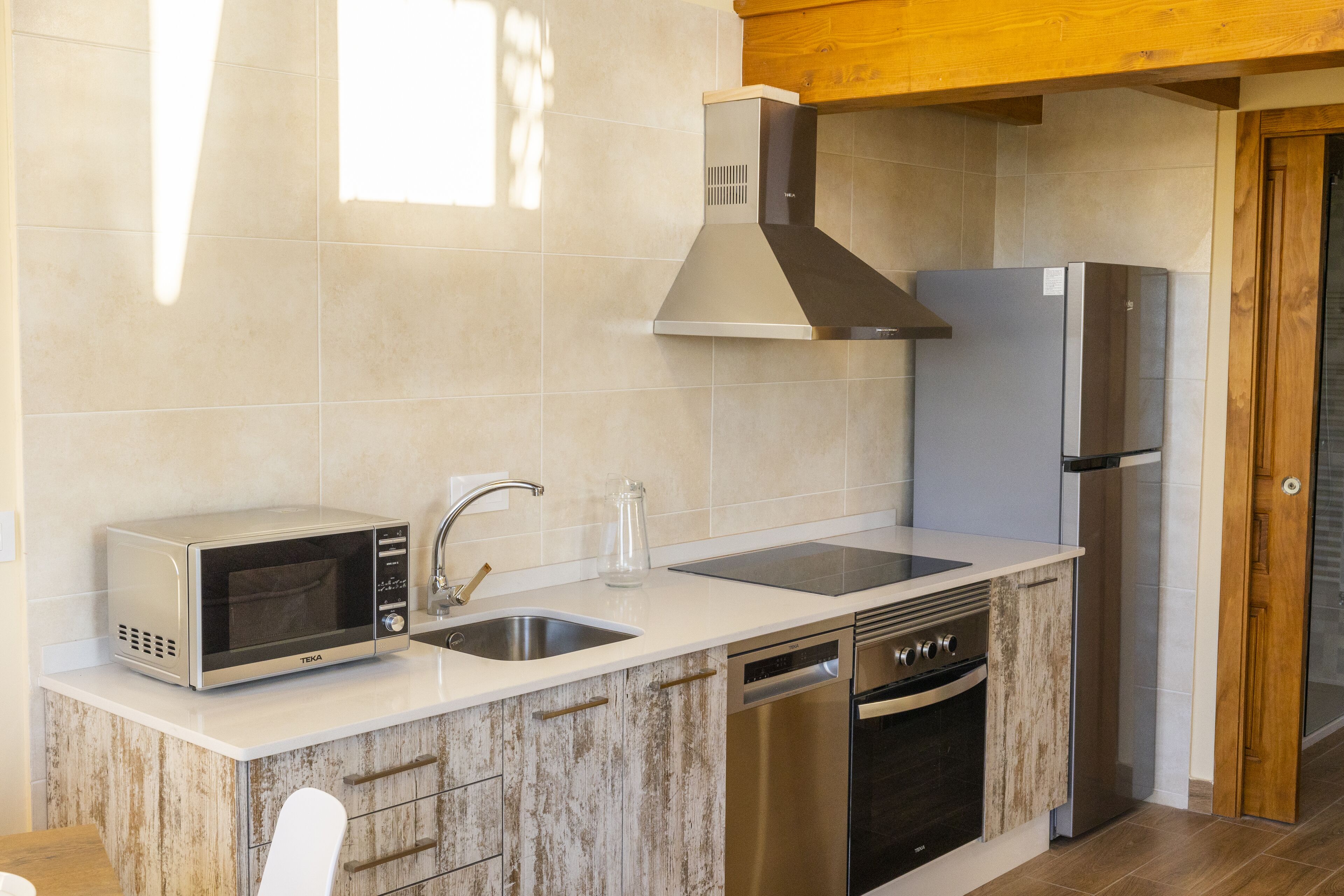 Une cuisine moderne équipée d’un four à micro-ondes, d’un évier, d’une cuisinière et d’un lave-vaisselle.