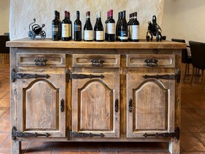 A wooden bar with multiple wine bottles and a small decorative item. - Gasthaus Alpina Salouf (Surses)