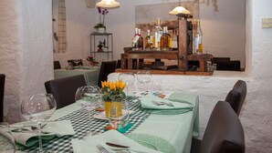 A dining table set with green tablecloth, plates, cutlery, and wine glasses. - Gasthaus Alpina Salouf (Surses)