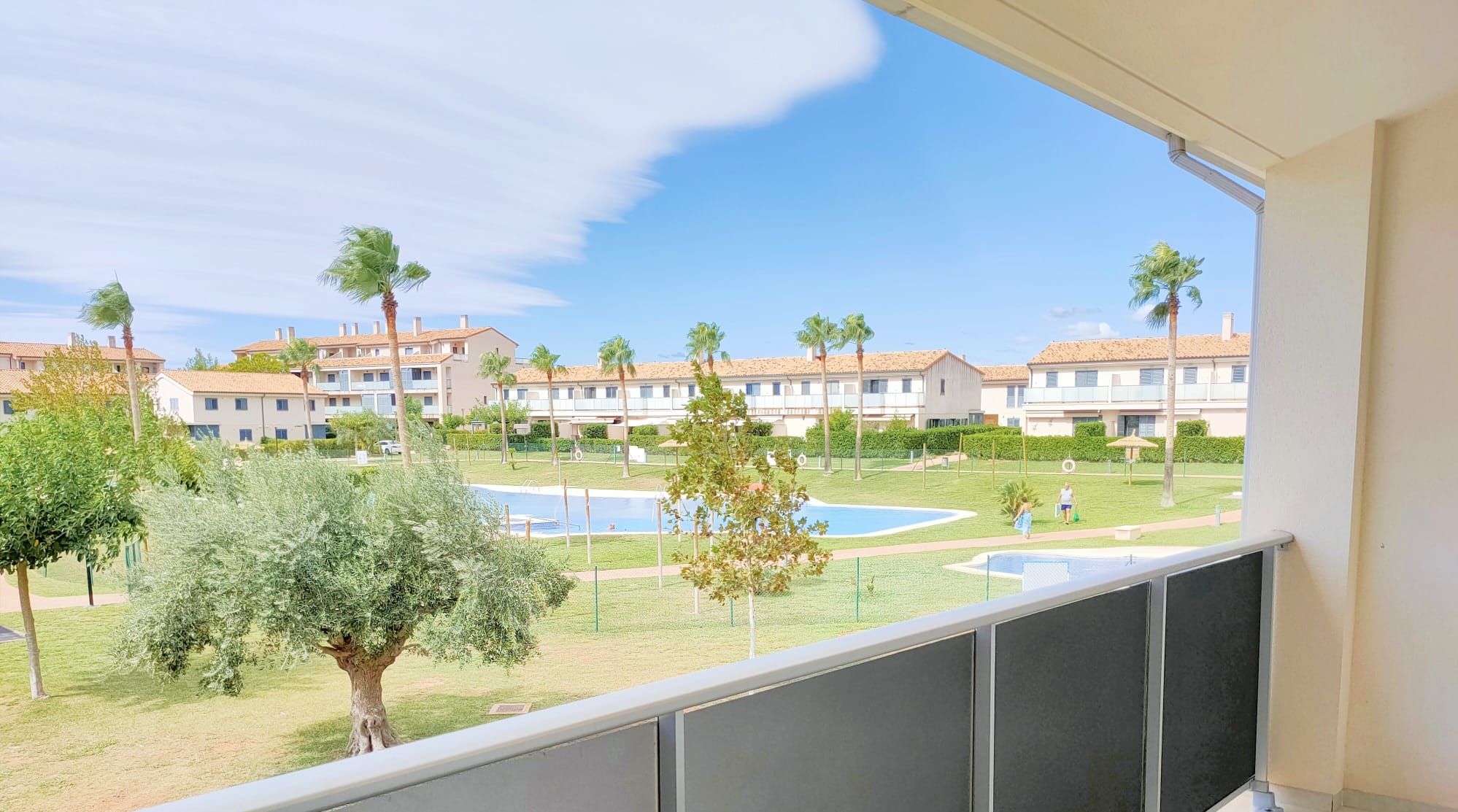 Un barrio residencial con varios edificios de apartamentos, una piscina y un césped cuidado.