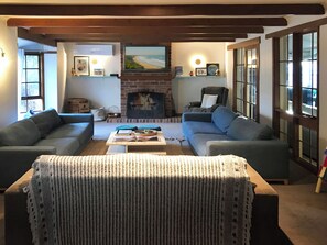 Cozy living room with a fireplace, two sofas, and a coffee table, perfect for relaxing and reading by the brick fireplace.