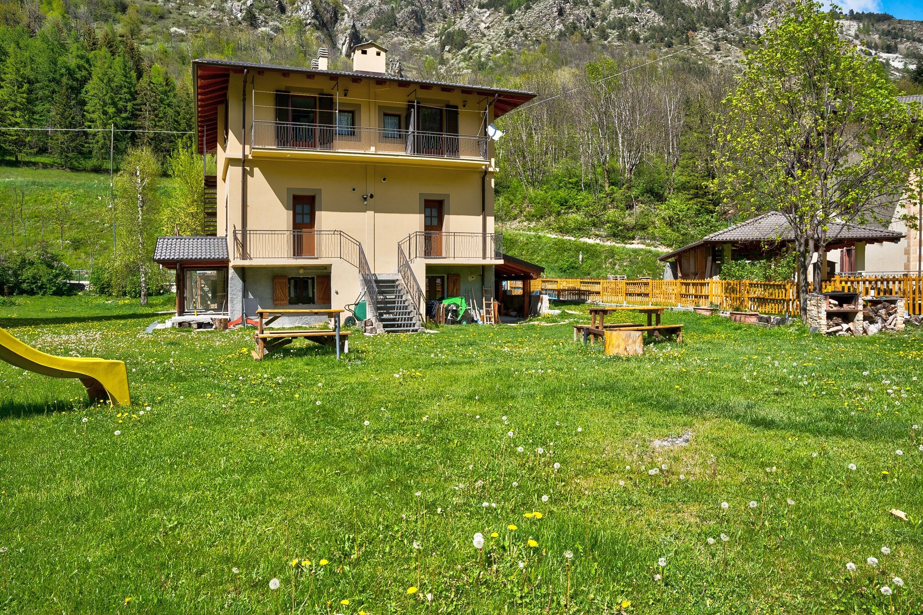 Ein zweistöckiges Gebäude mit Balkon, Treppe und einer Holzterrasse.