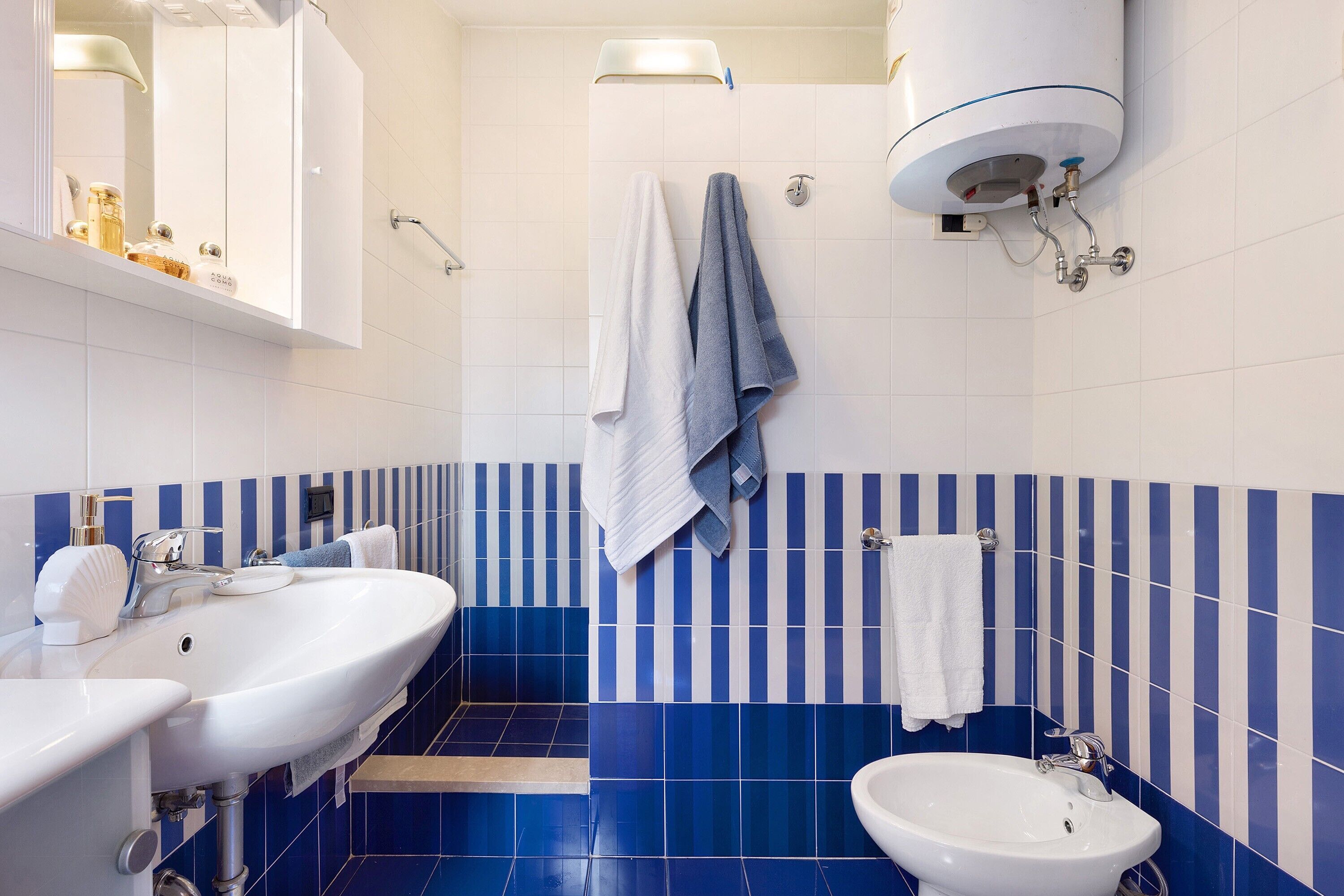 A bathroom with two sinks, a mirror, a towel rack, and a toilet.