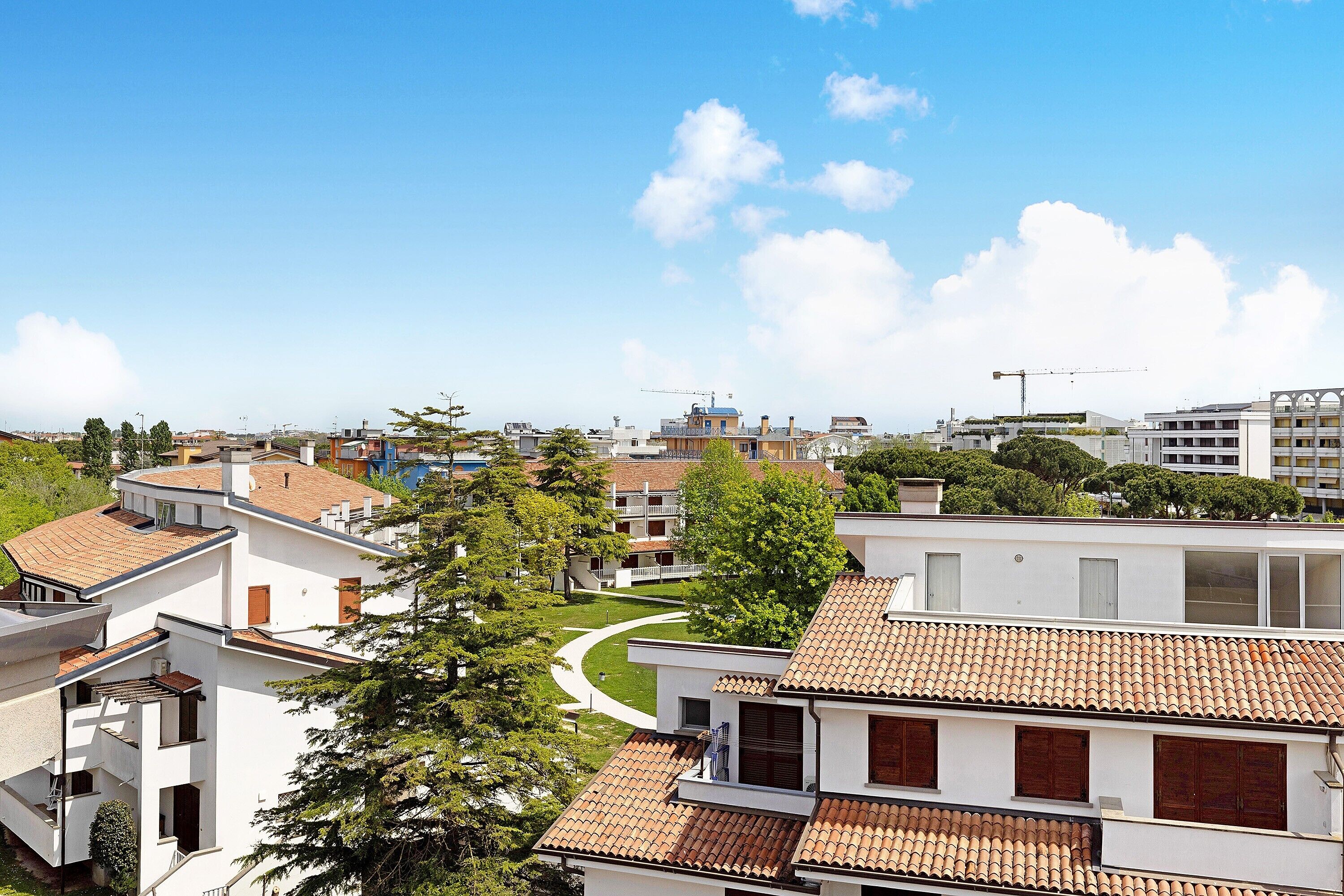 Een woonwijk met moderne gebouwen, een kronkelend pad en een helderblauwe lucht.
