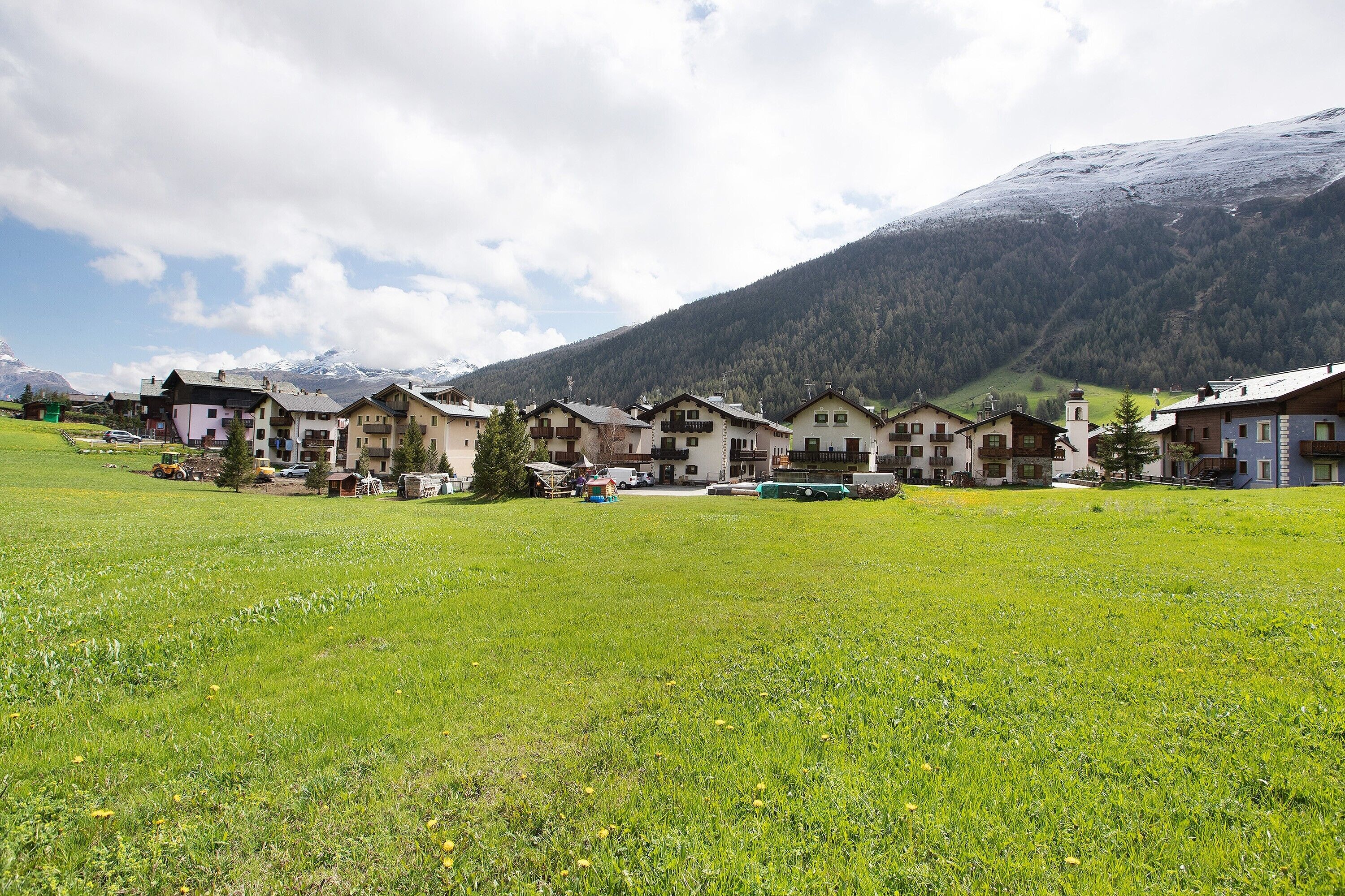 Una serie di edifici in stile chalet tradizionale con le montagne sullo sfondo.