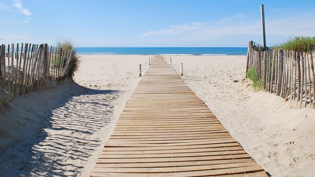 A wooden boardwalk leading to a sandy beach with a clear blue sky. - Apartment 'T2 Muses' with Private Terrace, Wi-Fi and Air Conditioning (Le Crès)