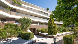 A multi-story hotel with balconies, a landscaped garden, and a clear sky. - Apartment 'T2 Muses' with Private Terrace, Wi-Fi and Air Conditioning (Le Crès)