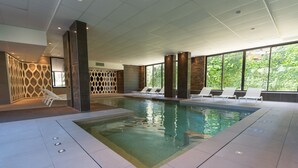 An indoor swimming pool with lounge chairs and large windows. - Apartment 'T2 Muses' with Private Terrace, Wi-Fi and Air Conditioning (Le Crès)