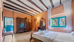 Ein Schlafzimmer mit einem Bett, einem Holzschrank und einem Fenster mit Vorhängen.