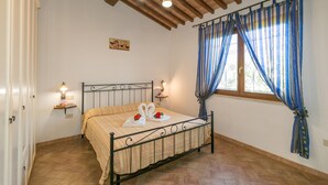 A bedroom with a bed, wooden ceiling beams, a window with curtains, and wall-mounted lights. - Farmhouse "Il Pino - Mandorlo" with Shared Pool, Private Terrace & Wi-Fi (Cecina)