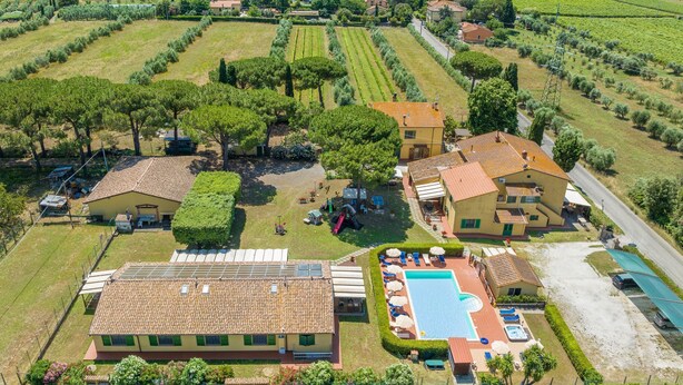 Luftaufnahme einer Anlage mit Swimmingpool, mehreren Gebäuden und umgebenden Weinbergen.