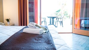 Une chambre d’hôtel avec un lit, une table de chevet avec un téléphone, une fenêtre avec des rideaux et une vue sur l’extérieur.