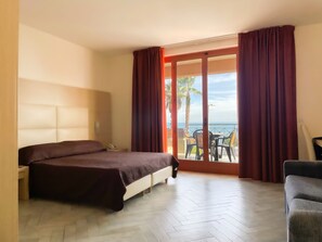 Habitación cuádruple Deluxe | Minibar, caja fuerte, escritorio y cortinas opacas