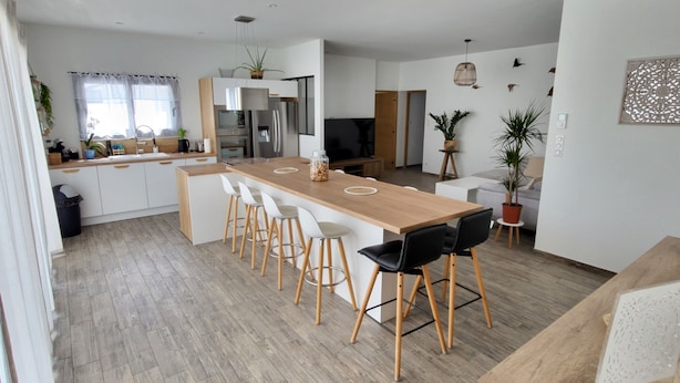 A modern kitchen with a central island, bar stools, and a dining area. - La Zenitude, a beautiful single-storey property with well-appointed features (Sérignan)