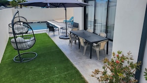 A modern outdoor patio with a pool, seating, and a dining area. - La Zenitude, a beautiful single-storey property with well-appointed features (Sérignan)
