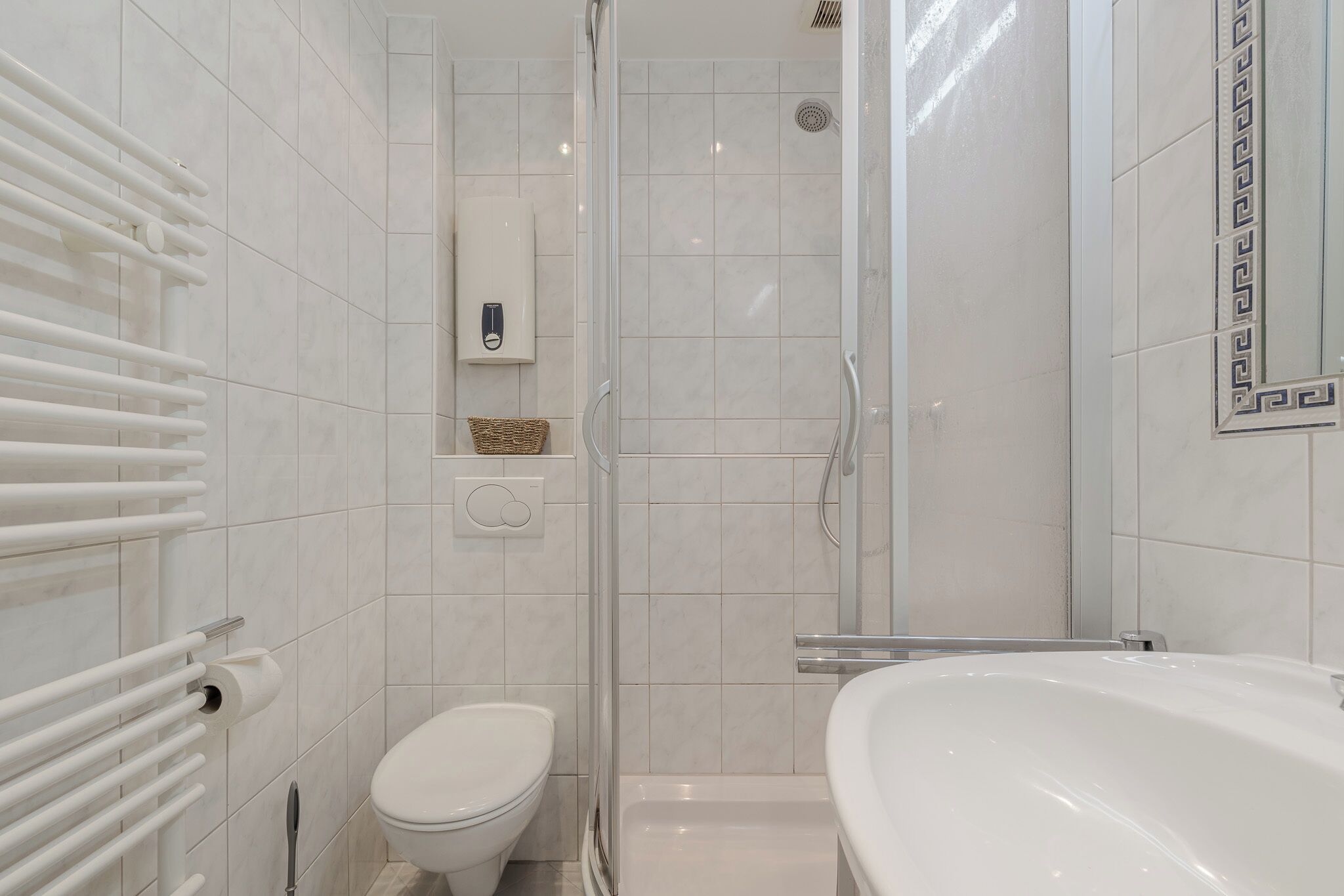 Une salle de bain moderne équipée de toilettes, d’une douche et d’une baignoire.
