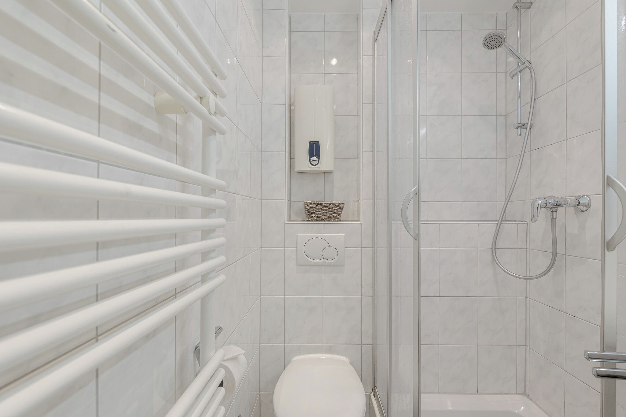 Une salle de bain moderne équipée de toilettes, d’une douche et d’un porte-serviettes.