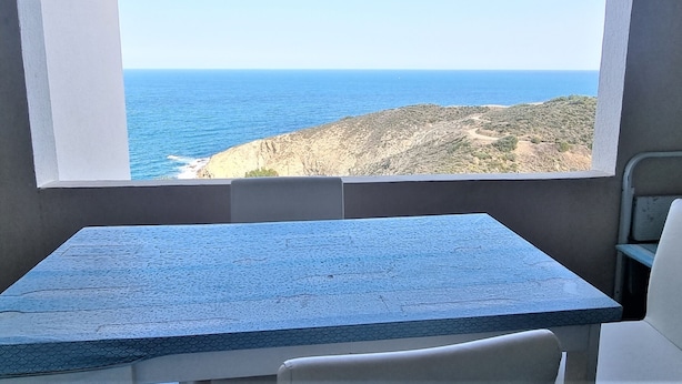 A room with a large window overlooking a coastal landscape. - T2 Apartment in Banyuls, terrace, parking, WIFI (Banyuls-sur-Mer)
