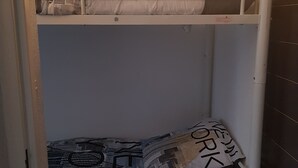 Una cama litera con un almohadón en la parte superior y un almohadón estampado en la inferior.