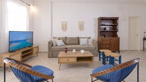 A living room with a sofa, coffee table, TV, and two blue chairs. - Rethymno Heart (Rethymno)