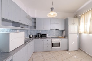 Una cocina moderna con armarios grises, un lavavajillas Bosch, un microondas, una cafetera y un refrigerador.