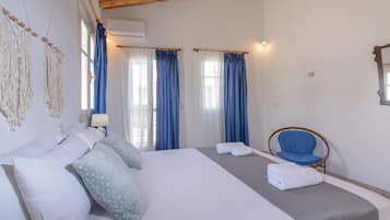Una habitación de hotel con cama, una silla y cortinas.