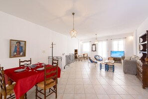 A spacious living area with a dining table set for four, a television, and a sofa. - Rethymno Heart (Rethymno)