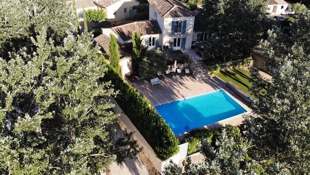 An aerial view of a property with a swimming pool, surrounded by lush greenery and multiple buildings. - Villa de Charme, à Proximité Immédiate D'uzes et du Pont du Gard (Argilliers)