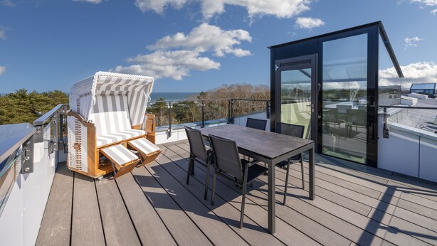 Eine Terrasse mit Tisch und Stühlen, mit Blick auf eine schöne Aussicht.