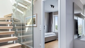 Ein modernes Interieur mit Treppe, Bett und Fernseher.