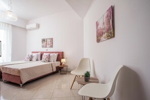 Una camera da letto moderna con un letto, comodini, una sedia e un condizionatore d'aria a muro.