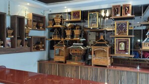 Una exhibición de casas de pájaros de madera y cuadros en una tienda.