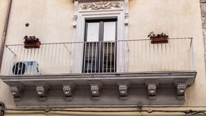Un edificio con balcón, una puerta con ventanal y un letrero que dice "Niria".