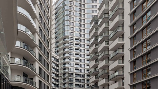 A high-rise residential building with multiple balconies and large windows. - Compact Studio in Wola | Balcony | Air Conditioning (Warszawa)