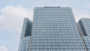 A tall, curved glass skyscraper with a sign reading "EVCONSTRUCTION" at the top. - Compact Studio in Wola | Balcony | Air Conditioning (Warszawa)
