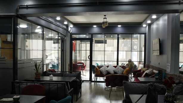 Un interior moderno con puertas de cristal que dan a una zona de estar exterior, con mesas y sillas.