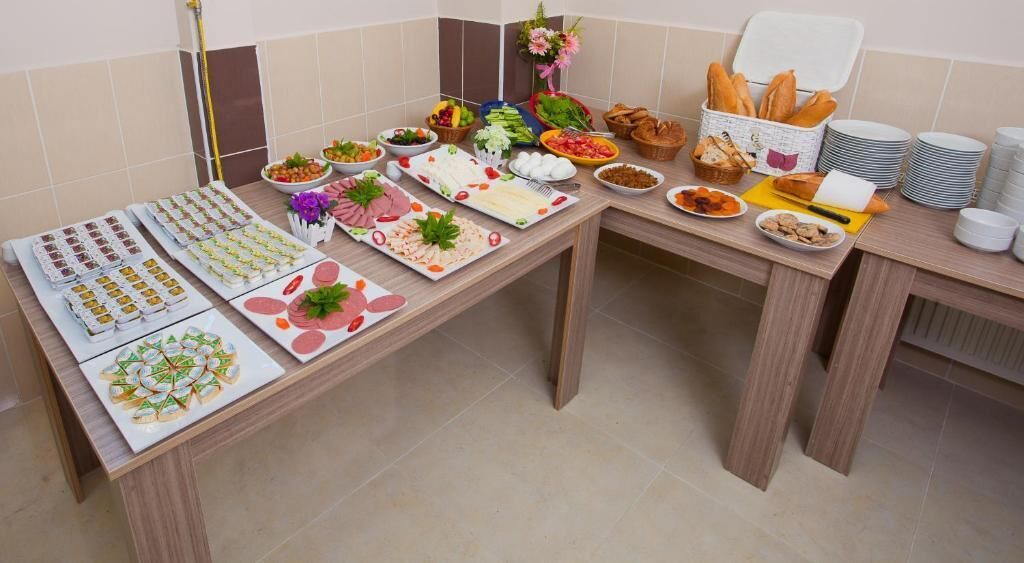 Una mesa de buffet con diversos alimentos y utensilios.