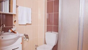 Un baño con inodoro, lavamanos y cabina de ducha.