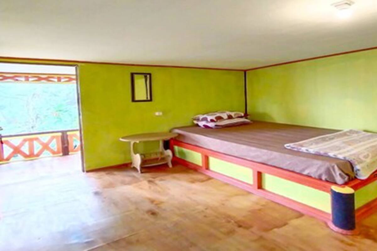 Una stanza con un letto, un tavolino e una finestra.