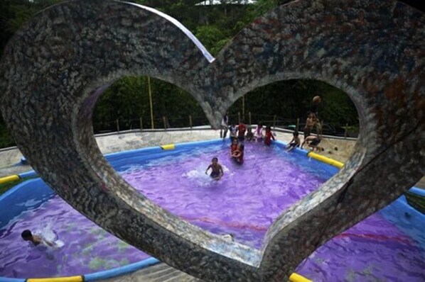 Une piscine dotée d’une structure en arc en forme de cœur.